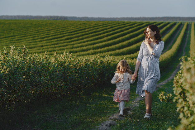 pregnant-mother-with-her-daughter-field_1157-38119